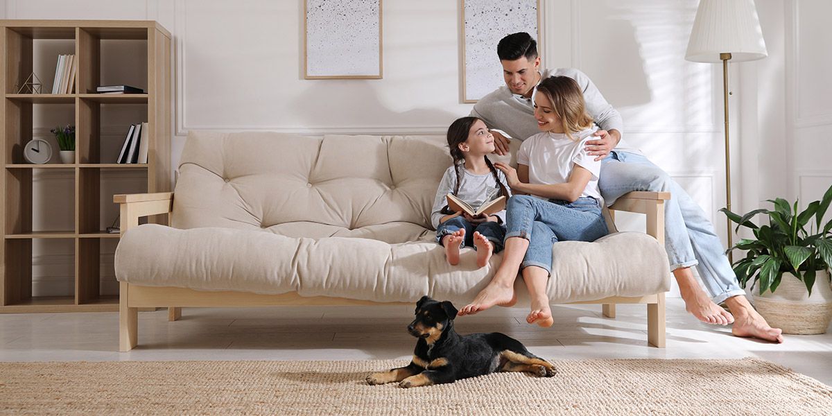 Glückliche Familie auf Sofa in Wohnzimmer